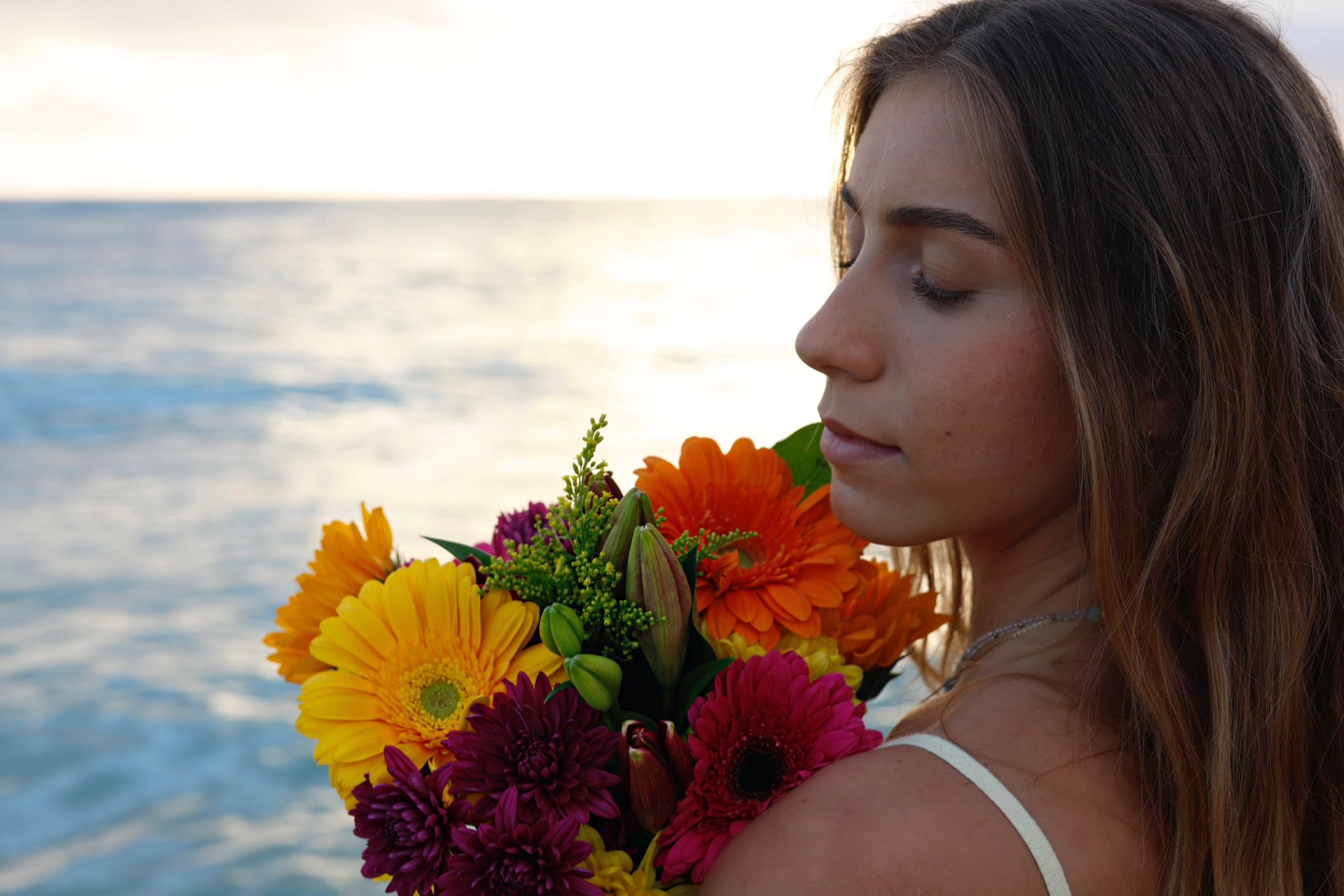 Girl with flowers with an ocean on background